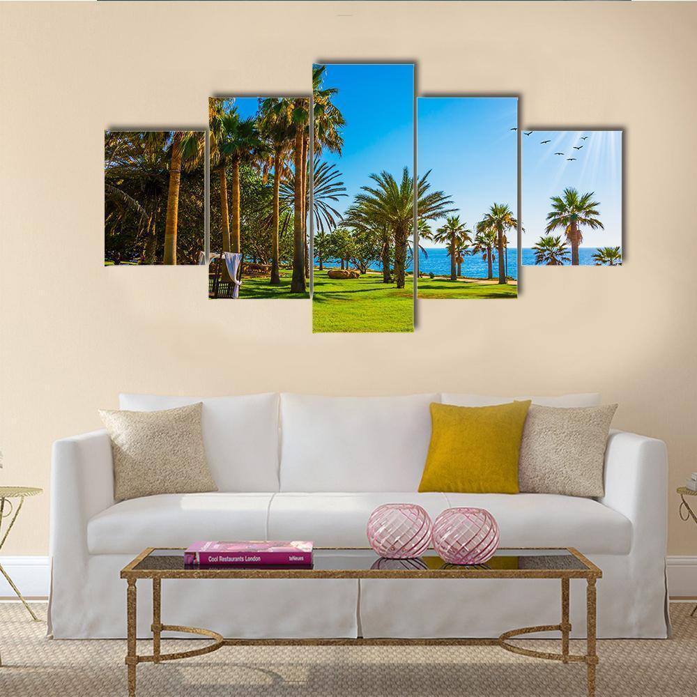 Palm Grove and Green Lawn Canvas Wall Art in green and blue, 5 panel Star layout hung on a wall
