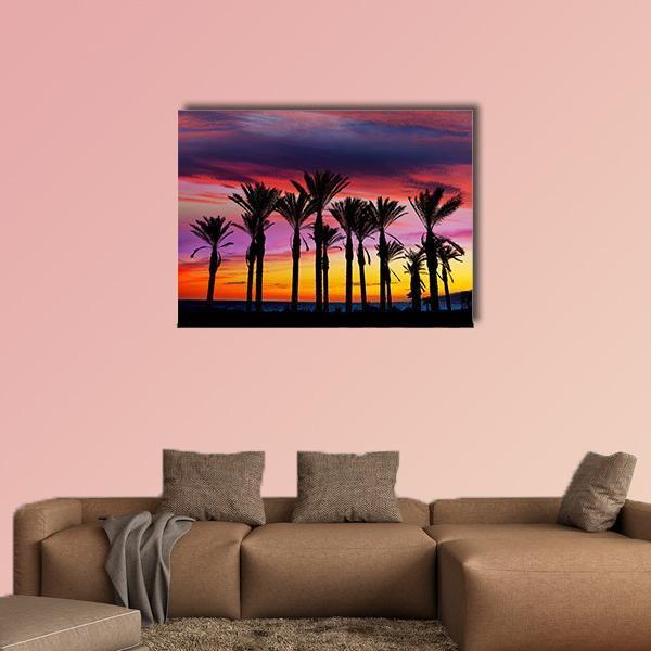 Retamar Beach Palm Trees at Sunset Canvas Wall Art in orange, purple and pink, single panel hung on a wall