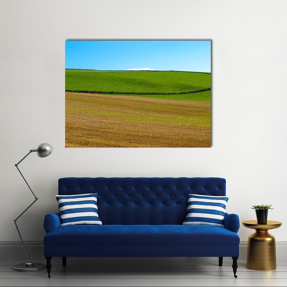 Rolling Hills and Low Stone Canvas Wall Art in brown, green and blue, single panel hung on a wall