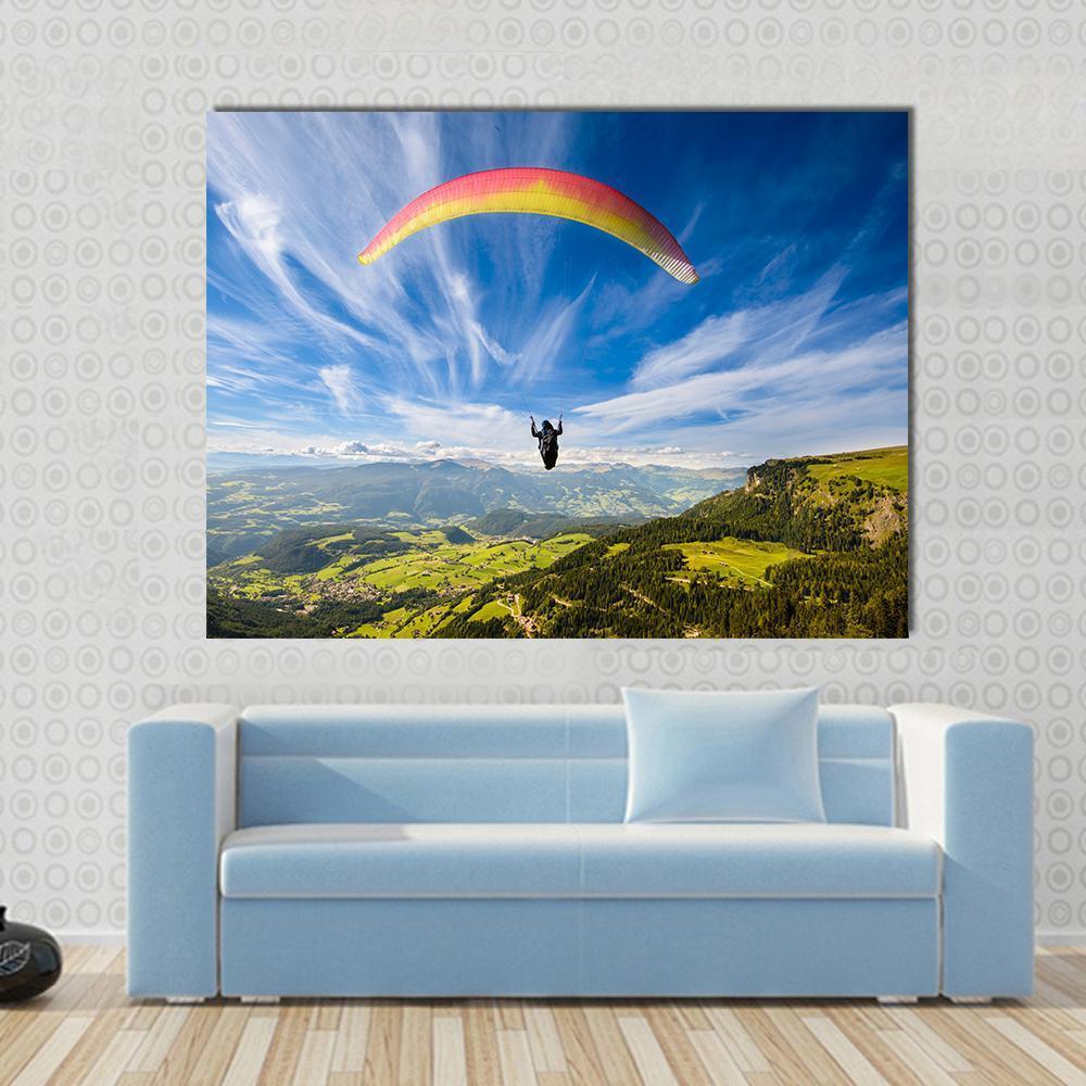 Paraglider Flying Over Mountains Canvas Wall Art in white, green and blue, single panel hung on a wall