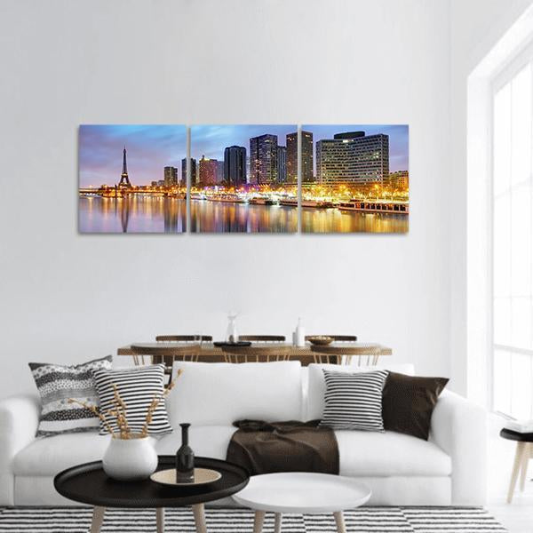 Paris Skyline at Night with Eiffel Tower Panoramic Canvas Wall Art in orange, yellow and blue, hung on a wall
