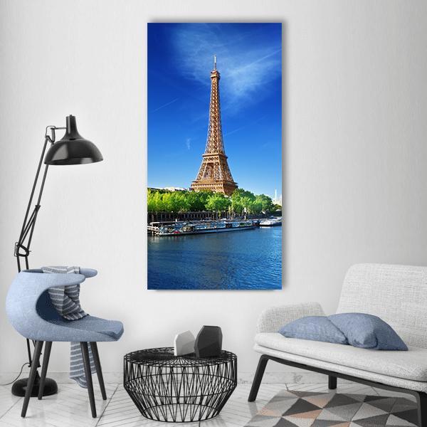 Eiffel Tower Over the Seine, Daytime Vertical Canvas Wall Art in brown, green and blue, single vertical panel hung on a wall