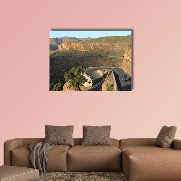 Winding Mountain Road Through Canyon Canvas Wall Art in brown, green and blue, single panel hung on a wall
