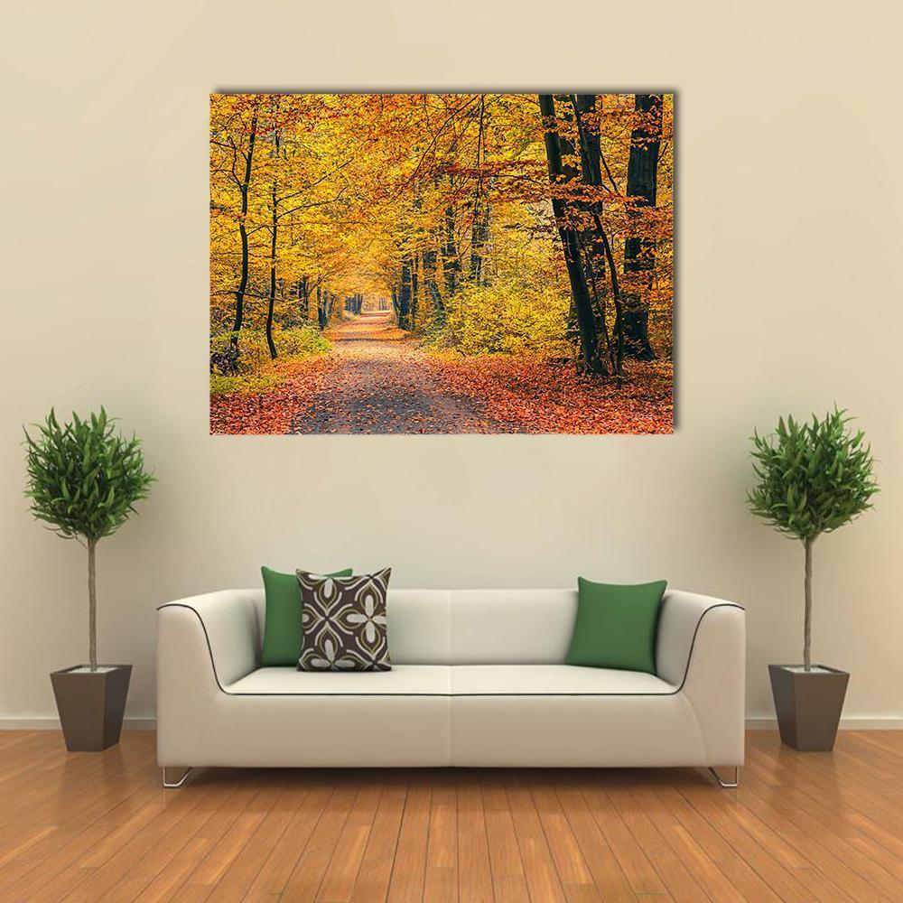 Autumn Forest Pathway Canvas Wall Art in brown, orange and yellow, single panel hung on a wall
