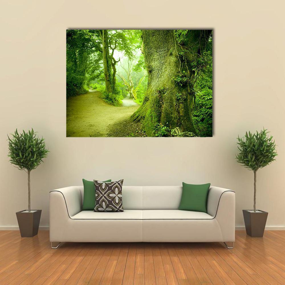 Misty Forest Path with Moss-covered Trunk Canvas Wall Art in brown, yellow and green, single panel hung on a wall