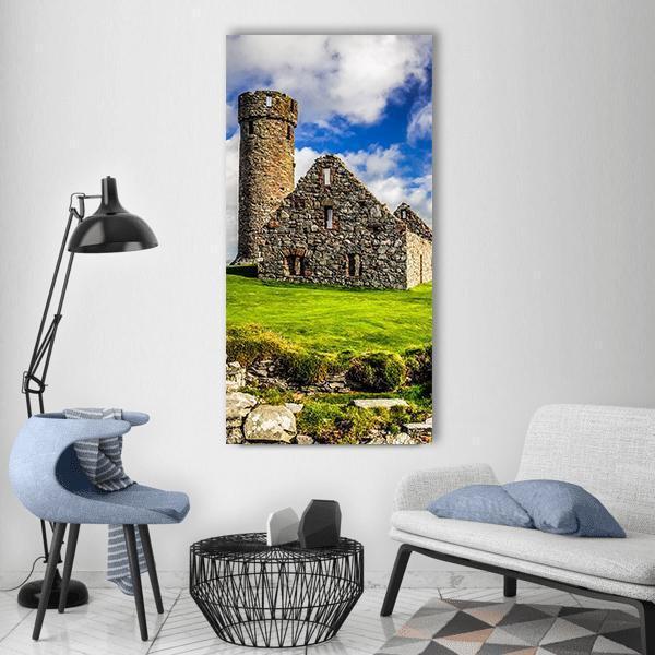 Peel Castle's Tower Vertical Canvas Wall Art in gray, green and blue, single vertical panel hung on a wall