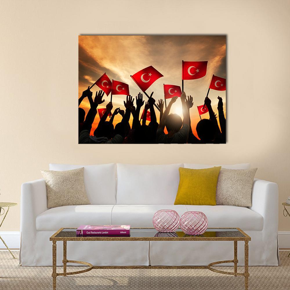 People Holding Turkish Flags Canvas Wall Art in black, red and orange, single panel hung on a wall