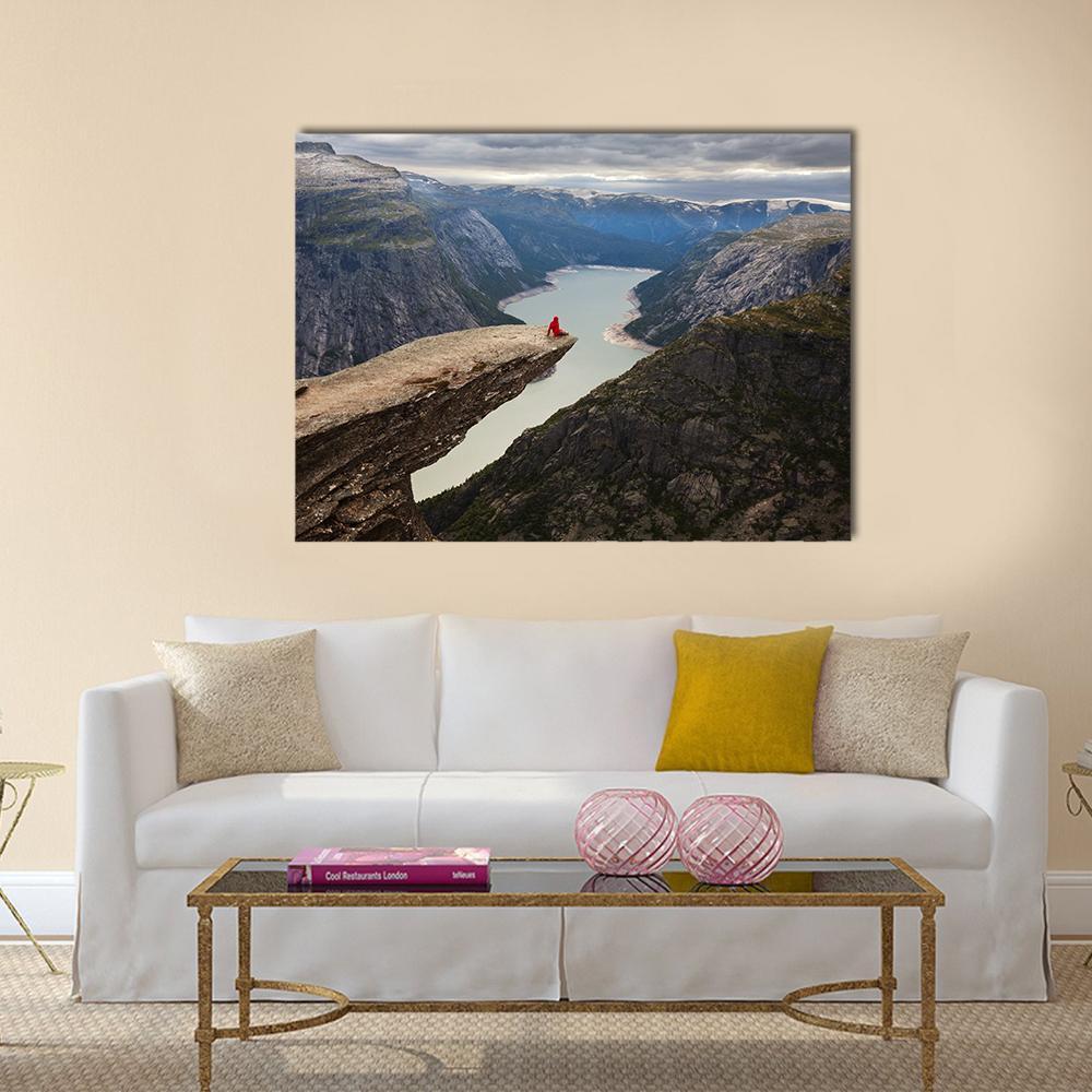 Hiker on Trolltunga Cliff Canvas Wall Art in gray, brown and blue, single panel hung on a wall