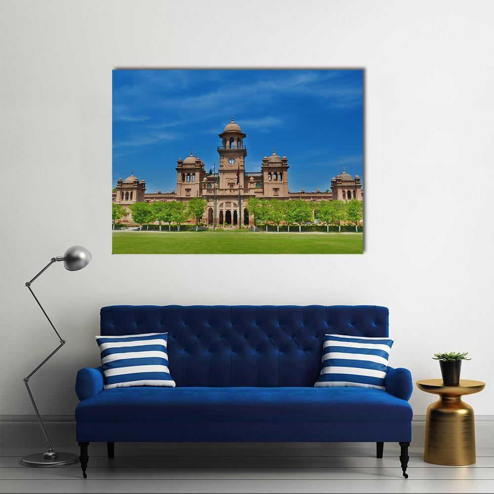Peshawar University Clock Tower Facade Canvas Wall Art in brown, green and blue, single panel hung on a wall