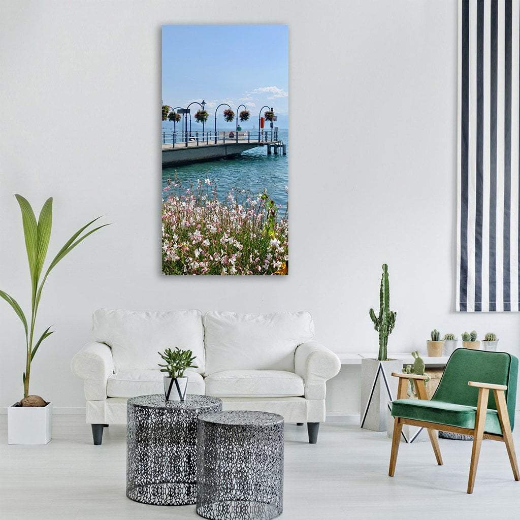 Pier with Pink and White Flowers Vertical Canvas Wall Art in green, blue and pink, single vertical panel hung on a wall