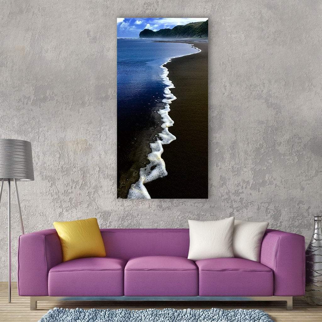 Piha Beach Foamy Waves and Dark Sand Vertical Canvas Wall Art in black, white and blue, single vertical panel hung on a wall