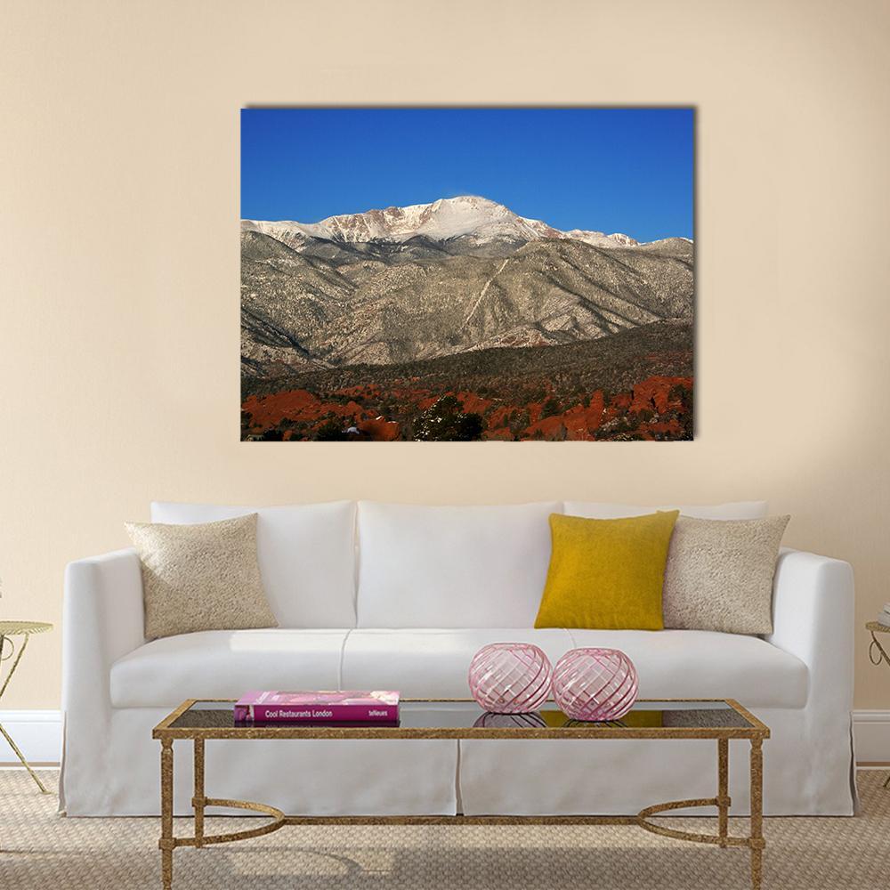 Red Rocks with Snow-capped Mountain Peaks Canvas Wall Art in brown, red and blue, single panel hung on a wall