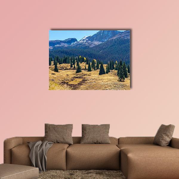 Pine Forest with Snow-capped Peaks Canvas Wall Art in brown, green and blue, single panel hung on a wall