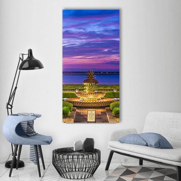 South Carolina Pineapple Fountain at Twilight Vertical Canvas Wall Art in yellow, blue and purple, single vertical panel hung on a wall