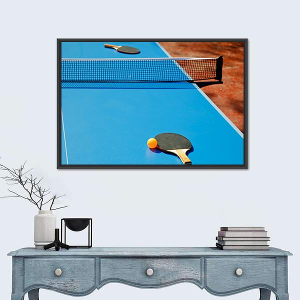 Ping Pong Ball with Paddle on Tennis Table Canvas Wall Art in black, orange and blue, framed canvas, product view on a white background