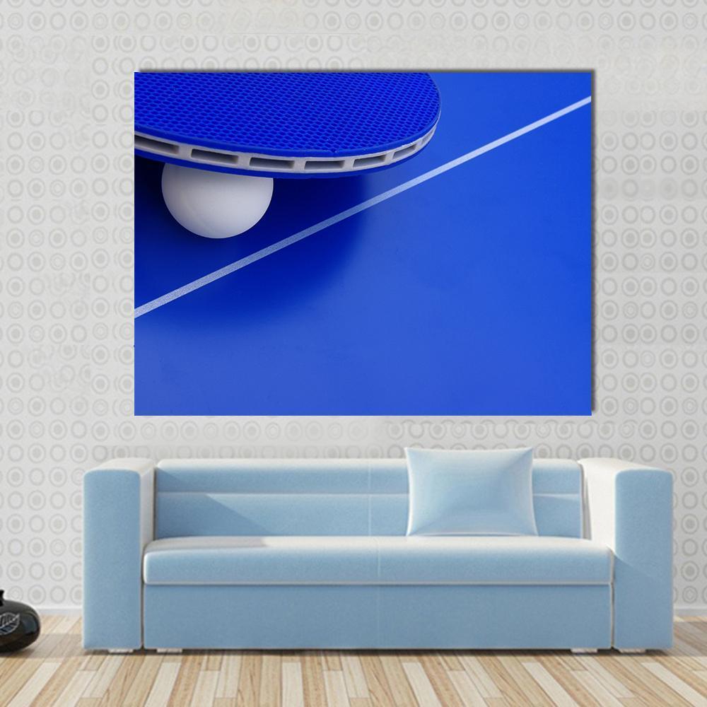 Ping Pong Ball and Racket on Table Canvas Wall Art in white and blue, single panel hung on a wall