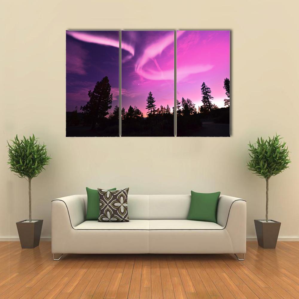 Pink Northern Lights Canvas Wall Art in black, purple and pink, 3 panel horizontal set hung on a wall