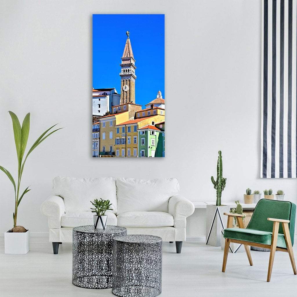 Piran Bell Tower and Church, Slovenia Vertical Canvas Wall Art in beige, yellow and blue, single vertical panel hung on a wall