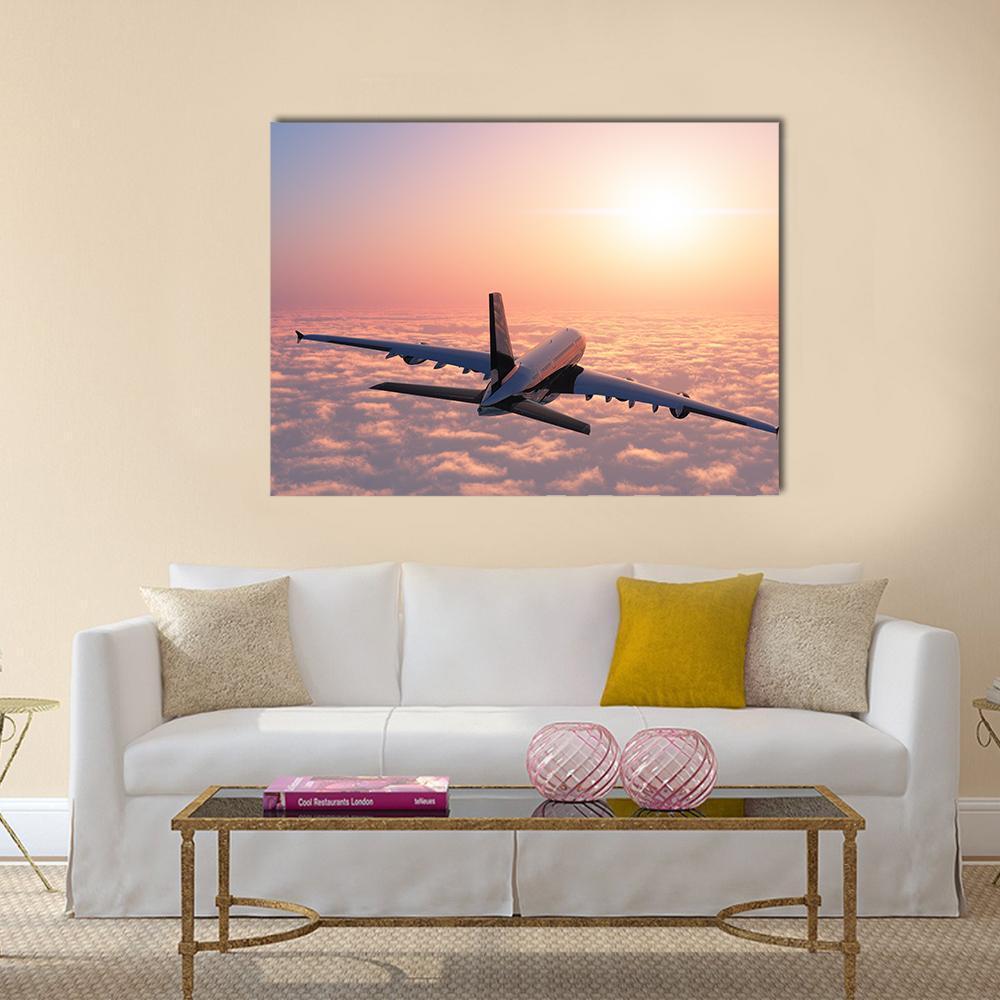 Airplane Flying Above Clouds Canvas Wall Art in orange, blue and pink, single panel hung on a wall