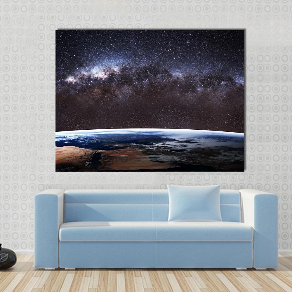 Planet Earth and Milky Way Canvas Wall Art in black, brown and blue, single panel hung on a wall