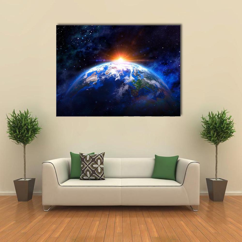 Earth from Space at Sunrise Canvas Wall Art in black, orange and blue, single panel hung on a wall
