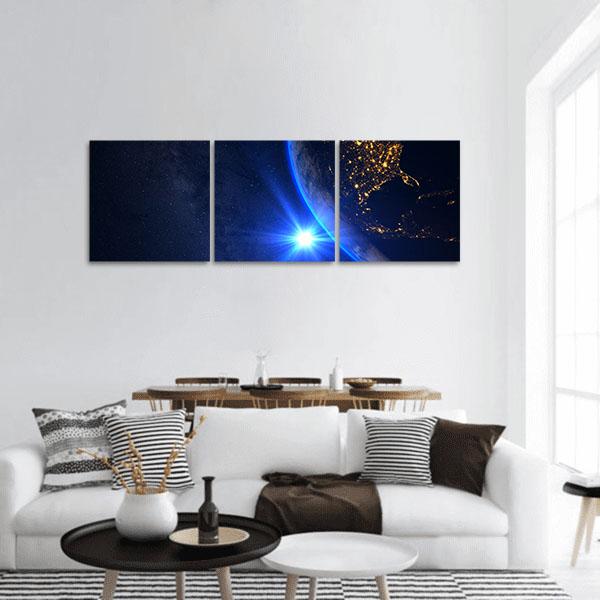 Earth from Orbit at Sunrise Panoramic Canvas Wall Art in black, gold and blue, hung on a wall