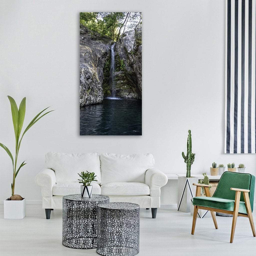 Forest Pond Waterfall Vertical Canvas Wall Art in black, gray and green, single vertical panel hung on a wall