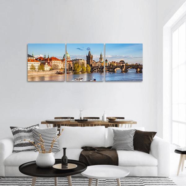 Charles Bridge Over the Vltava River Panoramic Canvas Wall Art in brown, orange and blue, hung on a wall