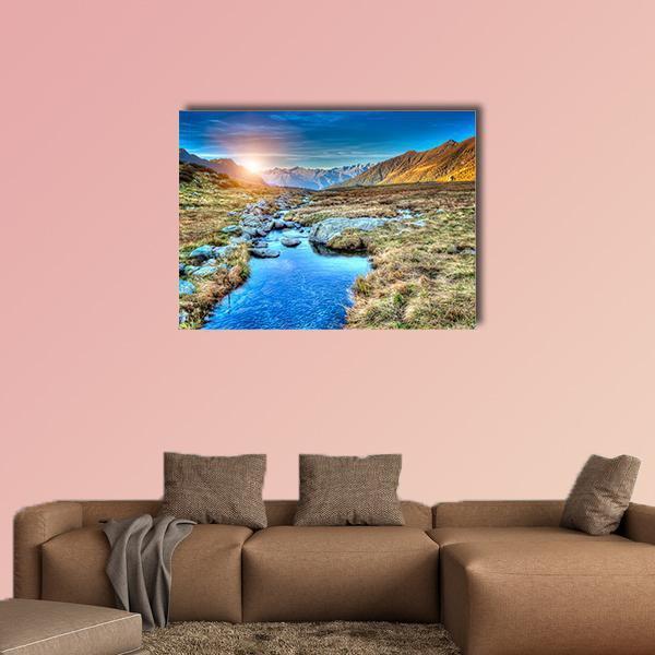 Prairie Sunset Over Mountain Stream Canvas Wall Art in brown, orange and blue, single panel hung on a wall