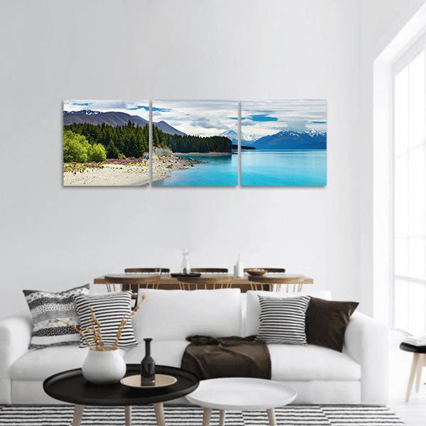 Pukaki Lake Turquoise Alpine Landscape Panoramic Canvas Wall Art in white, green and blue, hung on a wall