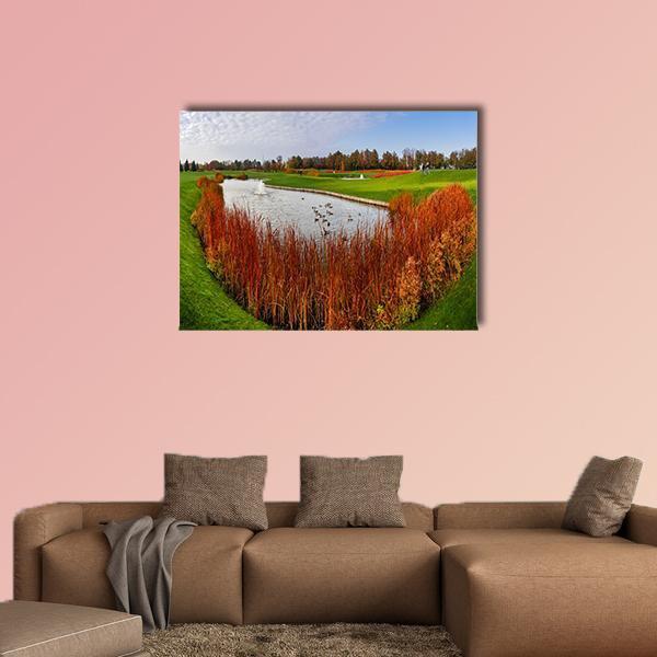 Pond and Green Meadow Canvas Wall Art in orange, green and blue, single panel hung on a wall