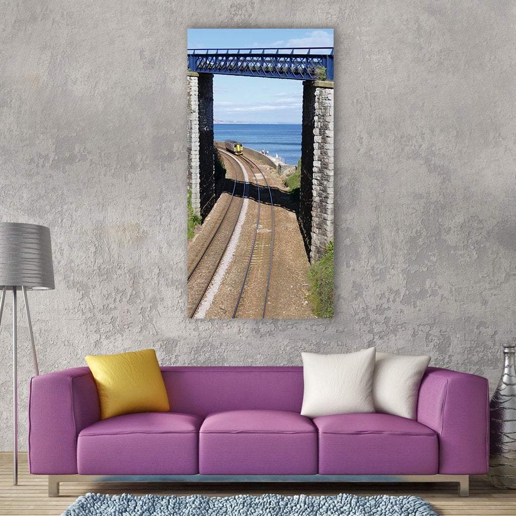Railway Track with Yellow Train and Bridge Vertical Canvas Wall Art in gray, brown and blue, single vertical panel hung on a wall