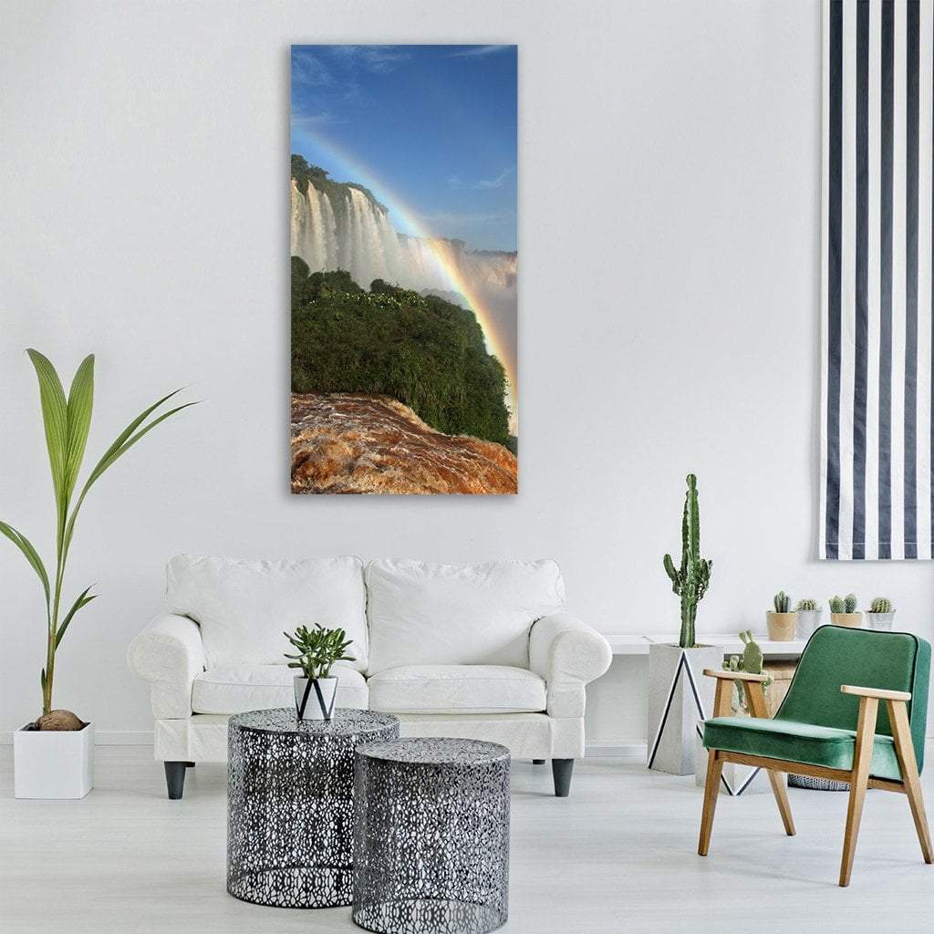 Rainbow Over Iguazu Falls Vertical Canvas Wall Art in brown, green and blue, single vertical panel hung on a wall