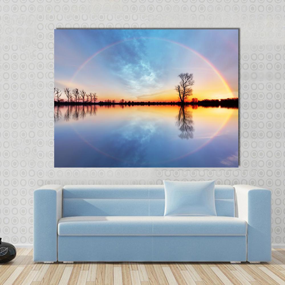 Rainbow Over Trees on Lake Sunrise Canvas Wall Art in orange, blue and multicolor, single panel hung on a wall