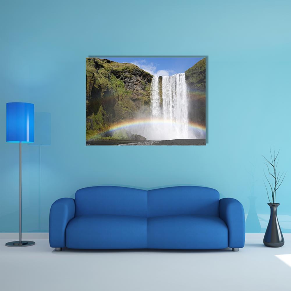 Skogafoss Rainbow Waterfall Canvas Wall Art in white, green and blue, single panel hung on a wall