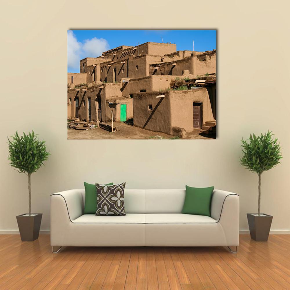 Ranchos De Taos Adobe Village Canvas Wall Art in beige, brown and blue, single panel hung on a wall