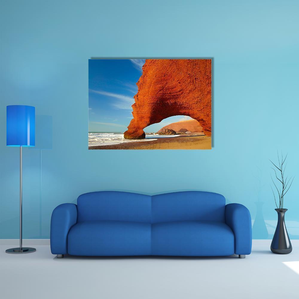 Reddish Rock Arch Framing Ocean Waves Canvas Wall Art in red, orange and blue, single panel hung on a wall