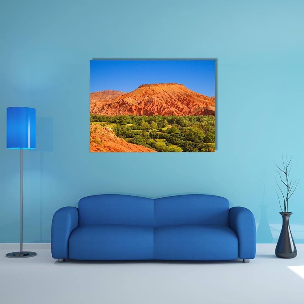 Red Hill Over Dades Valley Canvas Wall Art in orange, green and blue, single panel hung on a wall