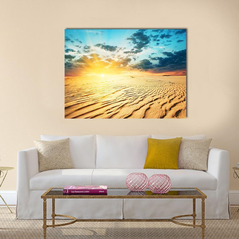 Desert Dunes Under a Red Sunset Canvas Wall Art in orange, yellow and blue, single panel hung on a wall