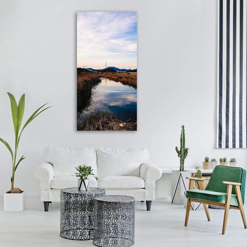 Clouds Reflected in Lake Vertical Canvas Wall Art in white, brown and blue, single vertical panel hung on a wall