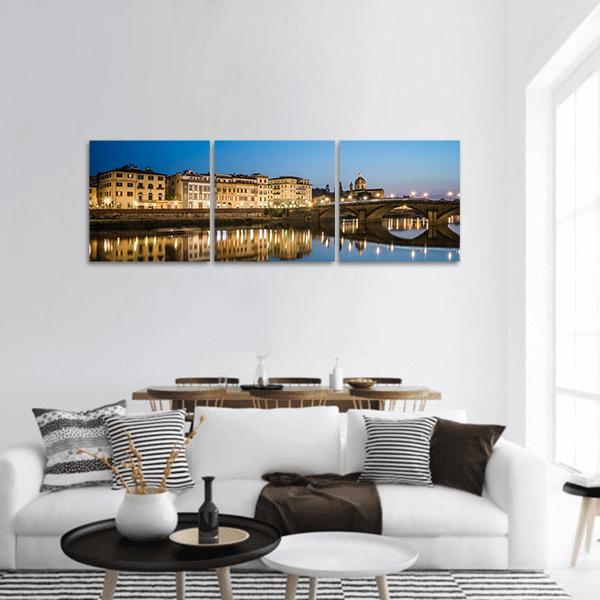 Arno River Reflections at Dusk Panoramic Canvas Wall Art in gold, yellow and blue, hung on a wall