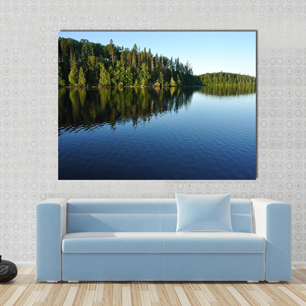 Reflections on a Coniferous Forest Lake Canvas Wall Art in green and blue, single panel hung on a wall