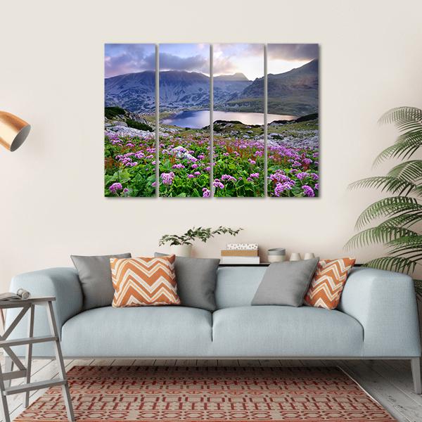 Alpine Lake with Purple Wildflowers Canvas Wall Art in green, blue and purple, single panel hung on a wall