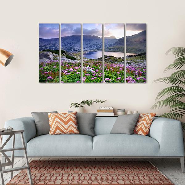 Alpine Lake with Purple Wildflowers Canvas Wall Art in green, blue and purple, single panel hung on a wall