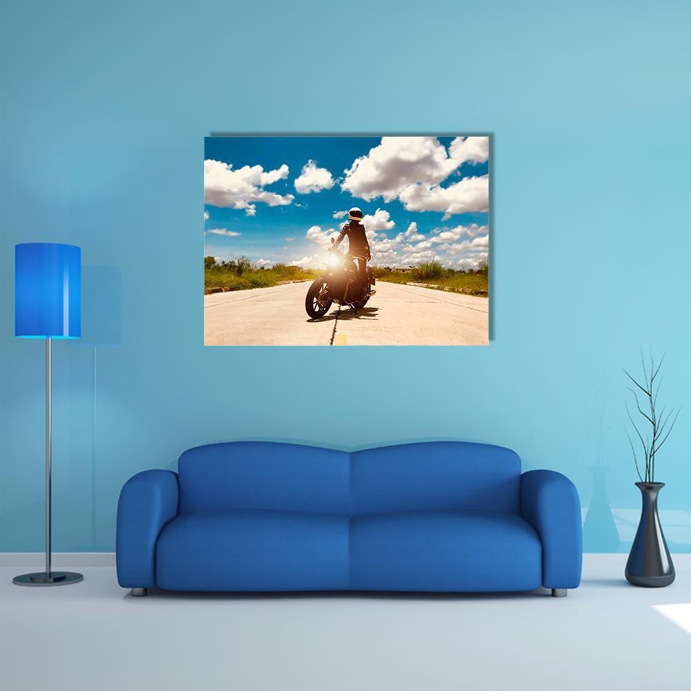 Sunlit Motorcycle Rider on Road Canvas Wall Art in white, beige and blue, single panel hung on a wall