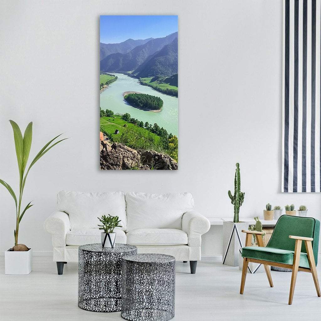 Winding River with Heart-shaped Island Below Misty Mountains Vertical Canvas Wall Art in gray, green and blue, single vertical panel hung on a wall