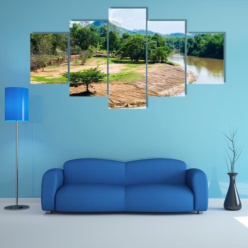 River Bend with Mountain Reflection Canvas Wall Art in brown, green and blue, 5 panel Star layout hung on a wall
