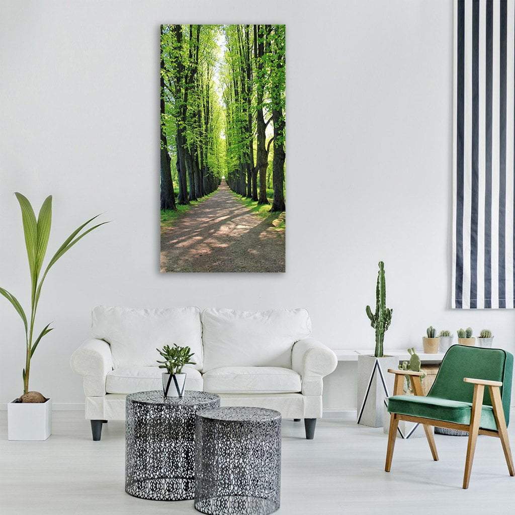 Road Between Avenue Trees Vertical Canvas Wall Art in brown and green, single vertical panel hung on a wall