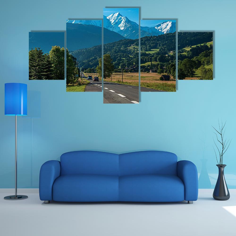 Winding Road Below Snow-capped Peaks Canvas Wall Art in gray, green and blue, 5 panel Star layout hung on a wall