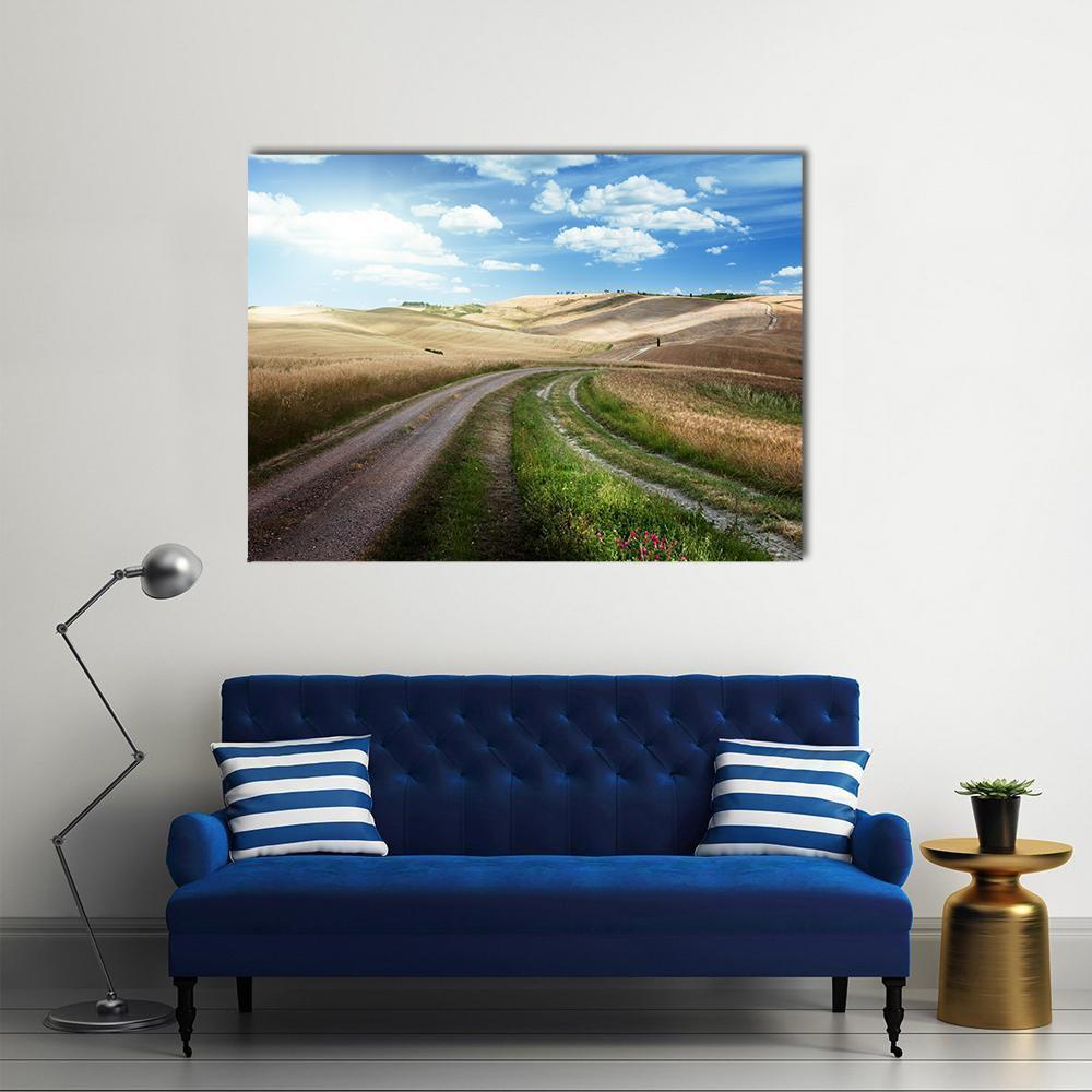 Winding Road Through Golden Wheat Fields Canvas Wall Art in brown, yellow and blue, single panel hung on a wall